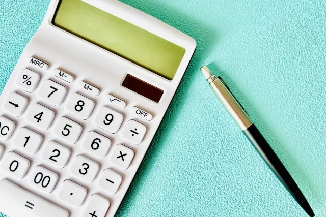 電卓とボールペンが置いてある